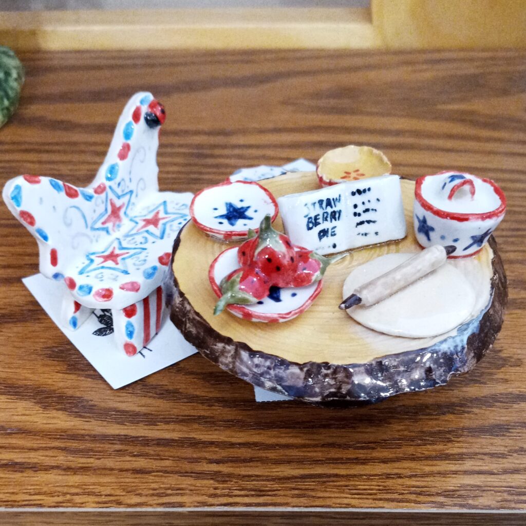 Miniature ceramic bench and table displaying the tools to make a mini pie