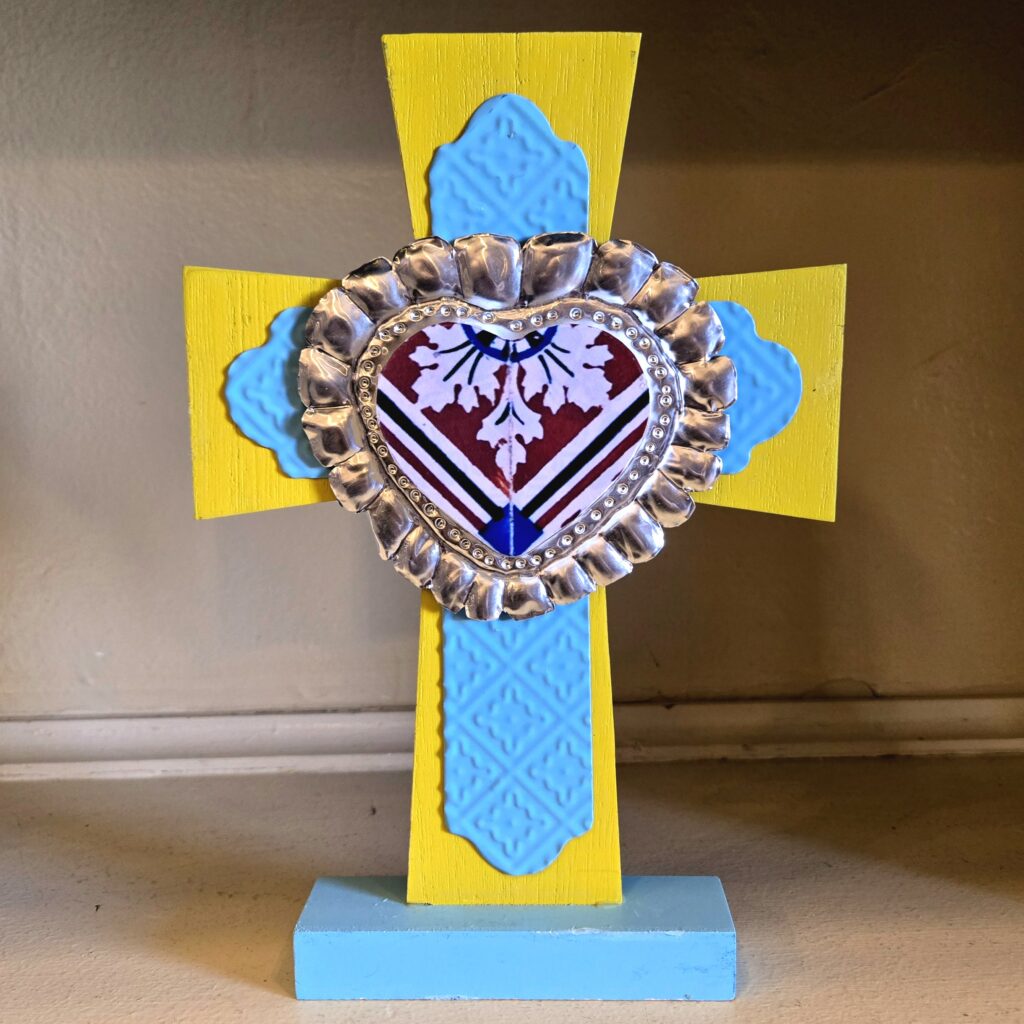 Wood and embossed tin standing cross, painted in yellow and blue